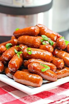 a white plate topped with cooked hot dogs next to an instant pot