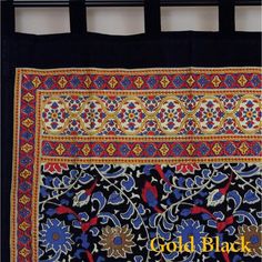 an embroidered black cloth with gold and blue designs on it, hanging from a hook