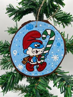 a christmas ornament hanging from a tree with snowflakes and candy cane