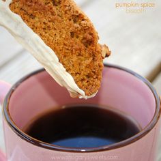 a piece of cake being dipped into a cup of coffee