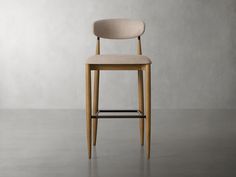 a wooden chair with a beige upholstered seat and back rests against a gray wall