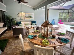 an outdoor dining area with wicker chairs and wooden table set for four, next to pool