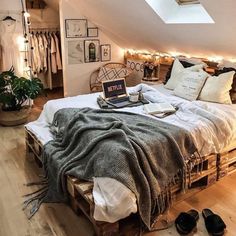 an attic bedroom with a bed made out of wooden pallets and lots of lights