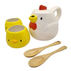 a yellow and white chicken cup with spoons next to it's holder, two wooden utensils