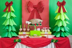 the dessert table is decorated with green and red paper trees, candy bars, and cupcakes