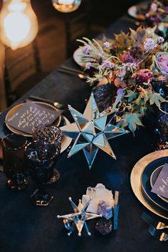 the table is set with blue and gold plates, napkins, and star centerpieces