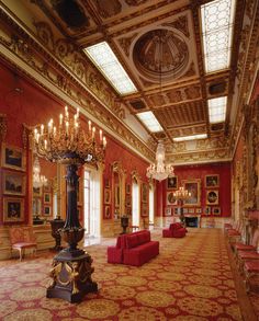 an ornately decorated room with red couches and chandeliers