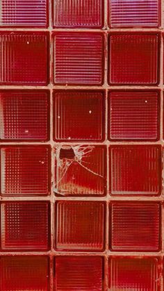 a red glass block wall with a broken window