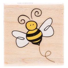 a wooden stamp with a drawing of a bee on it's back and the words,