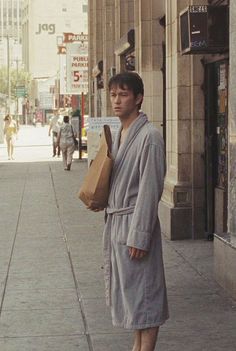 a man in a robe standing on the sidewalk