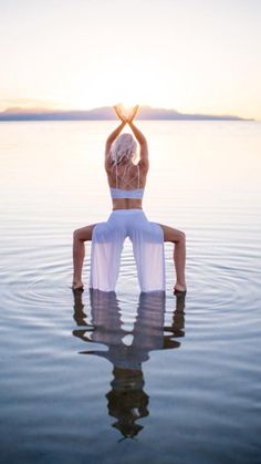 a woman sitting in the water doing yoga