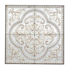 an intricately designed metal wall panel in white and gold with ornate designs on it