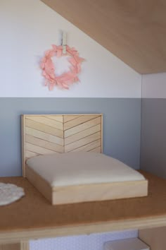 a bed with a wooden headboard on top of a desk next to a wreath