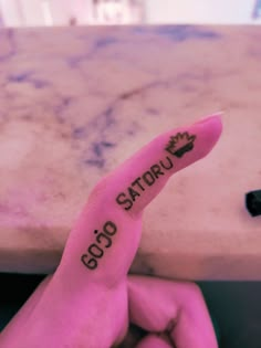 a person's finger with the word sogo satrou written on it in black ink