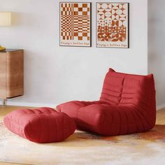 a red chair and ottoman in a room with two pictures on the wall behind it