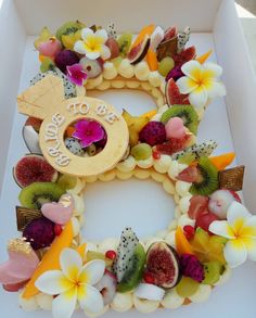 a white box filled with lots of fruit and flowers on top of it's sides