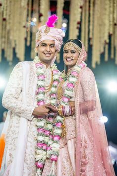 two people standing next to each other in wedding outfits