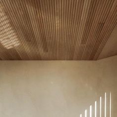 an empty room with wooden slats on the ceiling