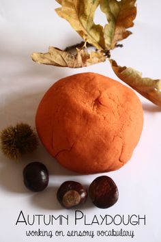 an orange and some leaves on a white surface