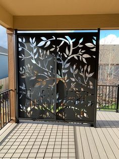 an iron gate with leaves on it in front of a deck and fenced area