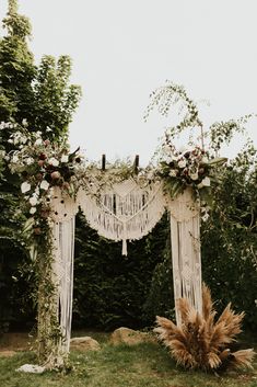 an outdoor wedding arch with flowers and greenery