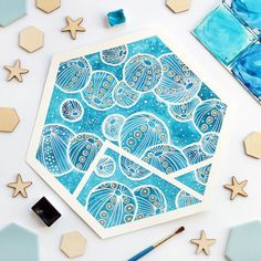 an art work with blue and white designs on it, surrounded by starfish and seashells