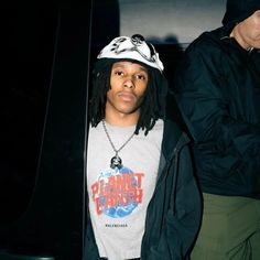 a young man with dreadlocks and a t - shirt