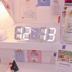 an alarm clock sitting on top of a desk next to a christmas tree and other decorations