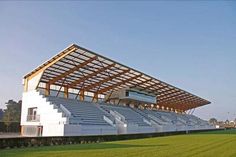 an empty soccer stadium with grass and blue sky in the backgroung area