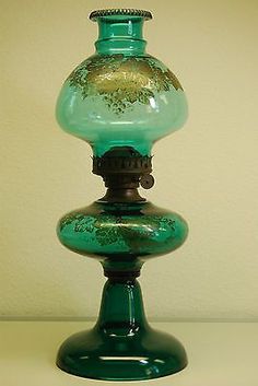 a green glass vase sitting on top of a table