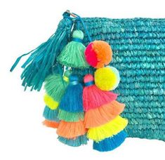 multicolored tasselled bag with pom - poms hanging from it