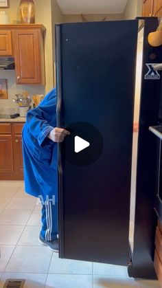 a man is opening the door to his kitchen with a blue blanket on it's back