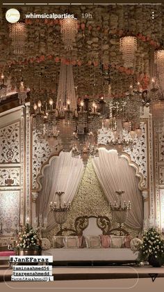 an elaborately decorated stage with chandeliers and flowers on the wall, is shown