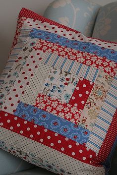 a red, white and blue patchwork pillow on a chair