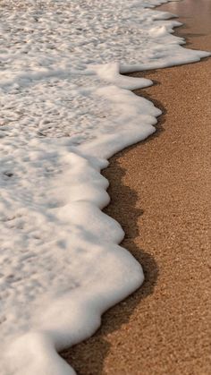 an ocean shore with waves crashing on the sand