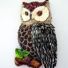 an owl statue sitting on top of a tree branch