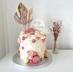 a birthday cake decorated with feathers and flowers