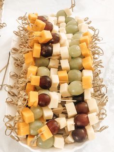 a platter filled with assorted cheeses and grapes