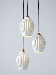 three white lamps hanging from black cords