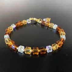 Dainty, stunning, and sparkly square cube crystal beaded bracelet with tiny  glass beads, and 18K and 24K plated components. This faceted square bead bracelet is beautiful!  Not too big or small, and it compliments so many styles.  Made from real crystal glass with gold beads hues of brown beads , champagne color beads,  and clear AB (aurora borealis).  Between the crystal beads, there are small glass Toho seed beads in matte gold.  This bracelet is lovely on its own, and easily stacks with othe Square Bead Bracelet, Crystal Beaded Bracelets With Sparkling Stones For Gifts, Gold Bead Bracelet, Color Bracelet, Gold Bead Bracelets, Color Beads, Crystal Beads Bracelet, Jewelry Studio, Square Bead