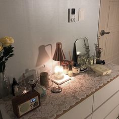 a table with candles, flowers and other items on it in front of a mirror