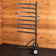 a large metal rack with wheels on the floor in front of a wood paneled wall