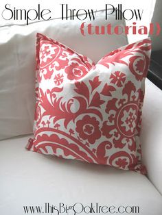 a red and white pillow sitting on top of a white couch with the words simple throw pillow