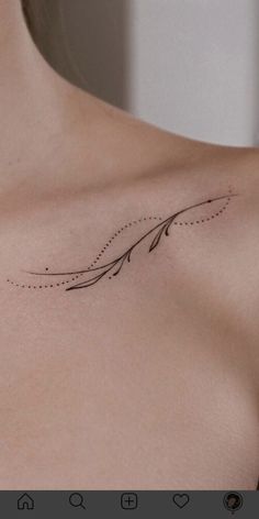 the back of a woman's shoulder with an arrow tattoo on it