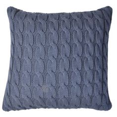 a blue knitted pillow on a white background