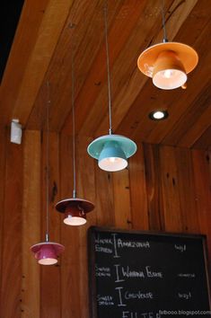 several lights hanging from the ceiling above a chalkboard