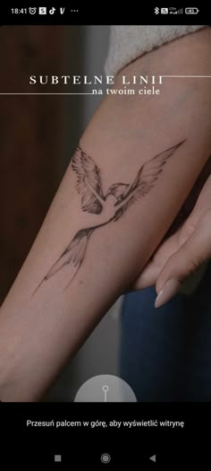 a woman's arm with a bird tattoo on it