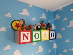 a child's room decorated in blue and white with cartoon characters on the wall