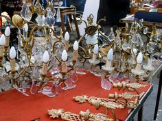 an assortment of glass and brass chandeliers are on display at a market stall