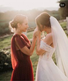 two women standing next to each other wearing wedding dresses